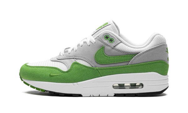 Nike Air Max 1 Patta “Chlorophyll” (HF1012-300) sneakers met een witte en grijze basis, groene chlorophyll accenten, golvende Patta mudguard, premium mesh en suède overlays, en de iconische zichtbare Air unit in de zool.