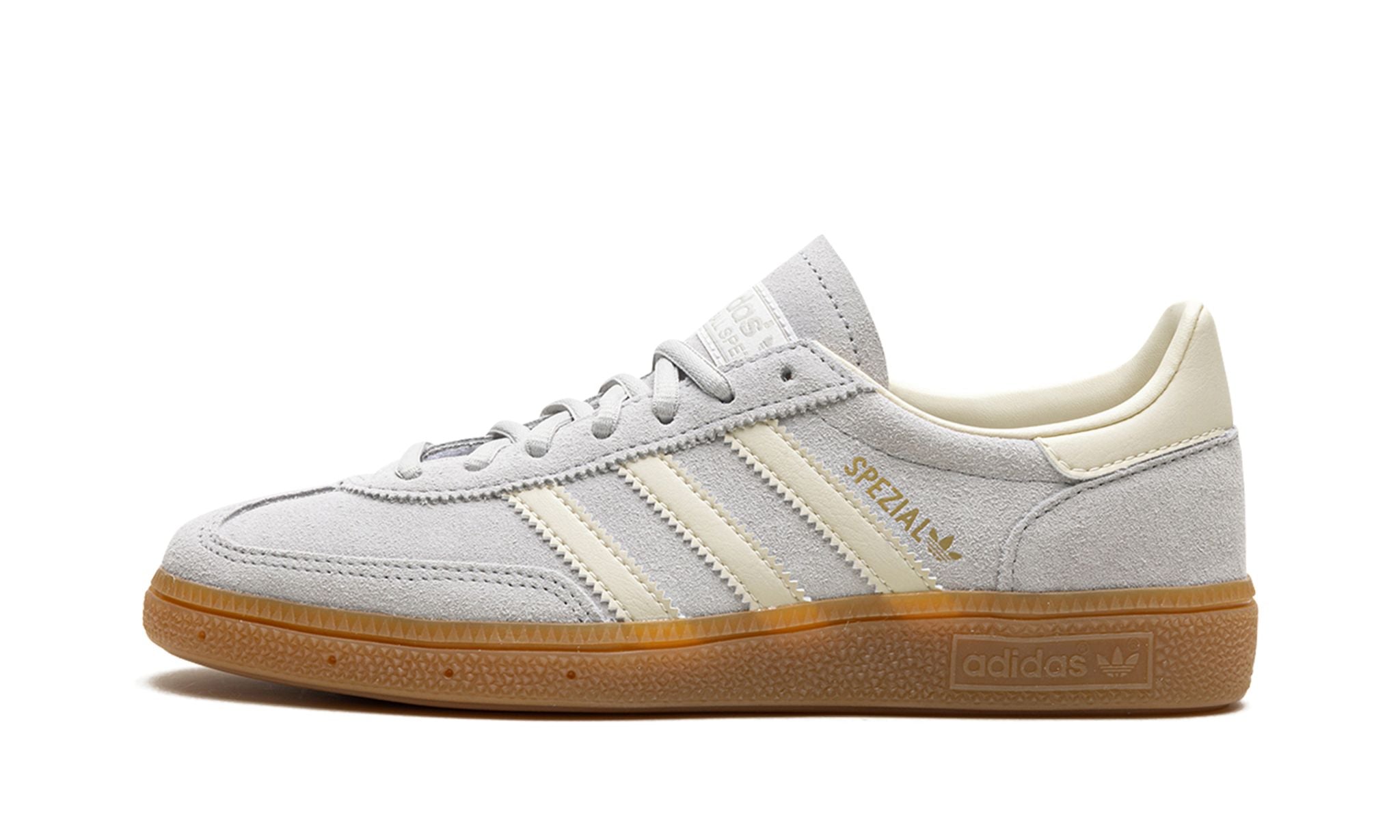 adidas Handball Spezial (IF7086) sneakers in een grijs en crème wit kleurenschema, uitgevoerd in zacht suède met de kenmerkende witte drie strepen, gum rubber zool en een klassiek low top retro silhouet.