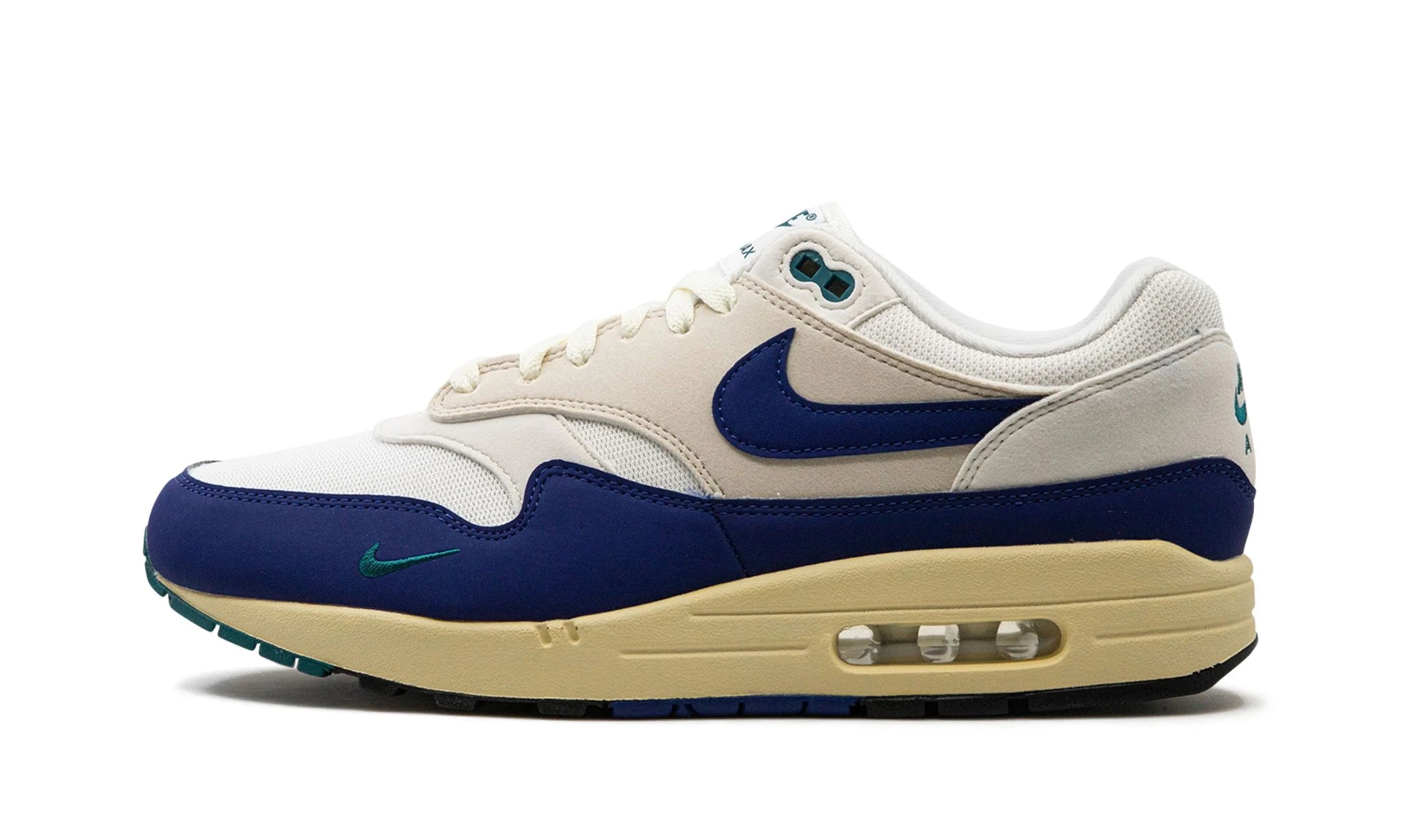 Nike Air Max 1 “Athletic Department Deep Royal Blue” (FQ8048) sneakers met een witte en lichtgrijze basis, gecombineerd met diepe royal blue accenten, premium mesh en suède overlays, en de iconische zichtbare Air unit in de zool.
