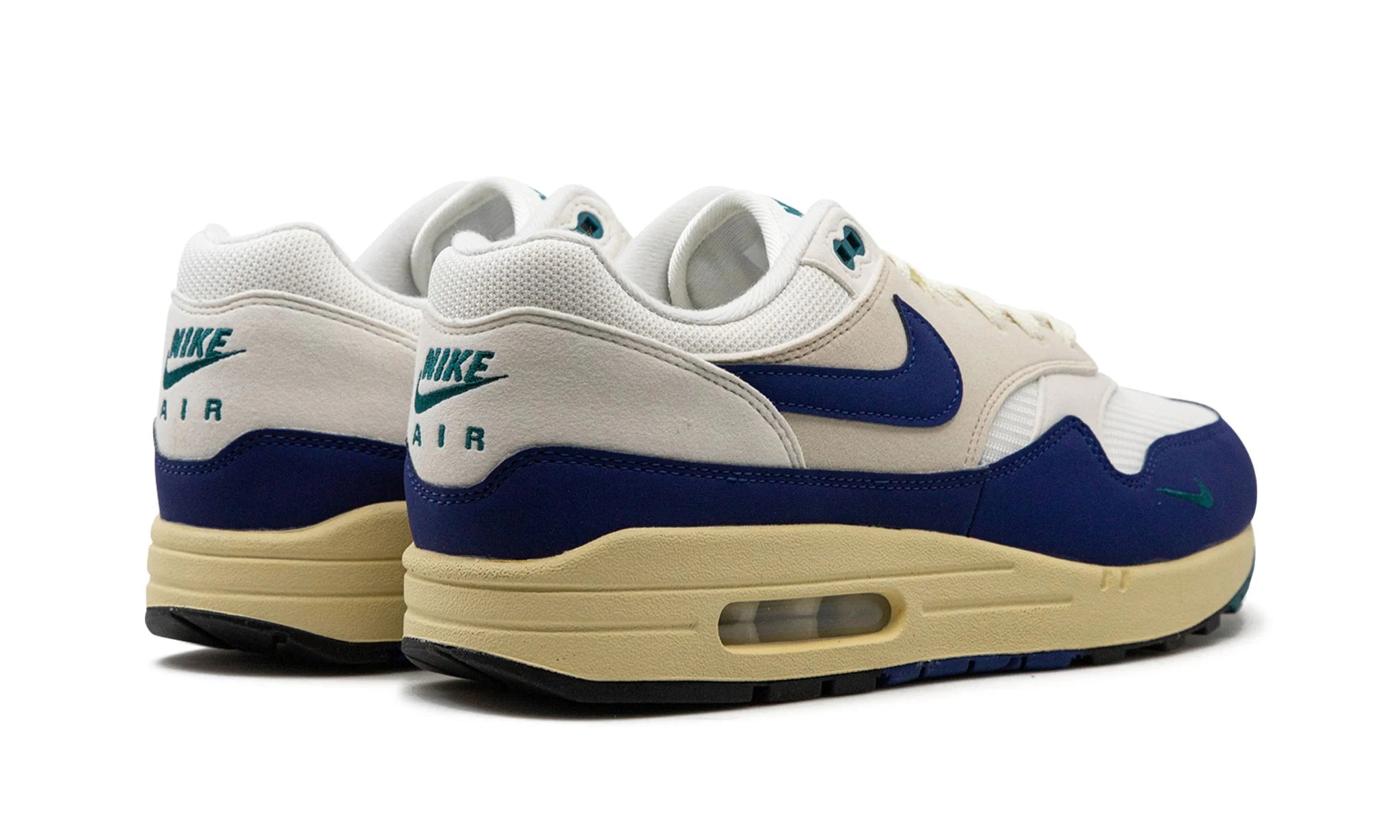 Nike Air Max 1 “Athletic Department Deep Royal Blue” (FQ8048) sneakers met een witte en lichtgrijze basis, gecombineerd met diepe royal blue accenten, premium mesh en suède overlays, en de iconische zichtbare Air unit in de zool.