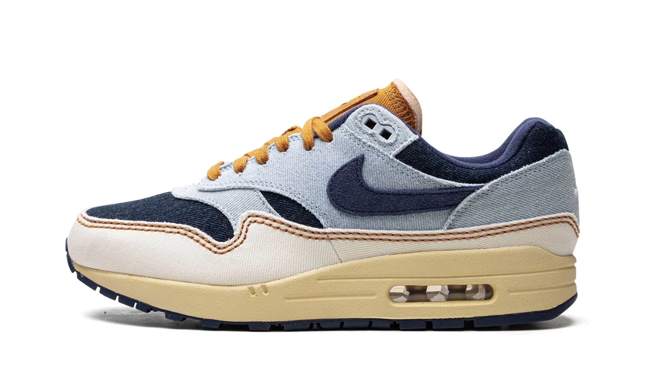 Nike Air Max 1 “Denim Aura” (FQ8900-440) sneakers met een mix van lichtblauw denim en zachte pastelaccenten, gecombineerd met mesh en suède overlays, en de iconische zichtbare Air unit in de zool.
